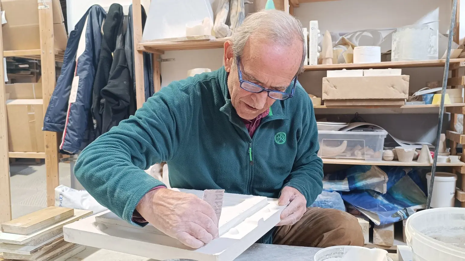 signore anziano che lavora un calco di marmo