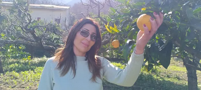 Donna con arancio e albero