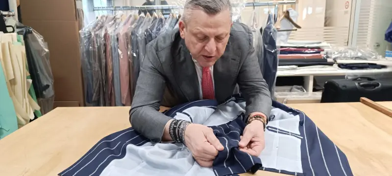 Persona che stende abito sartoria